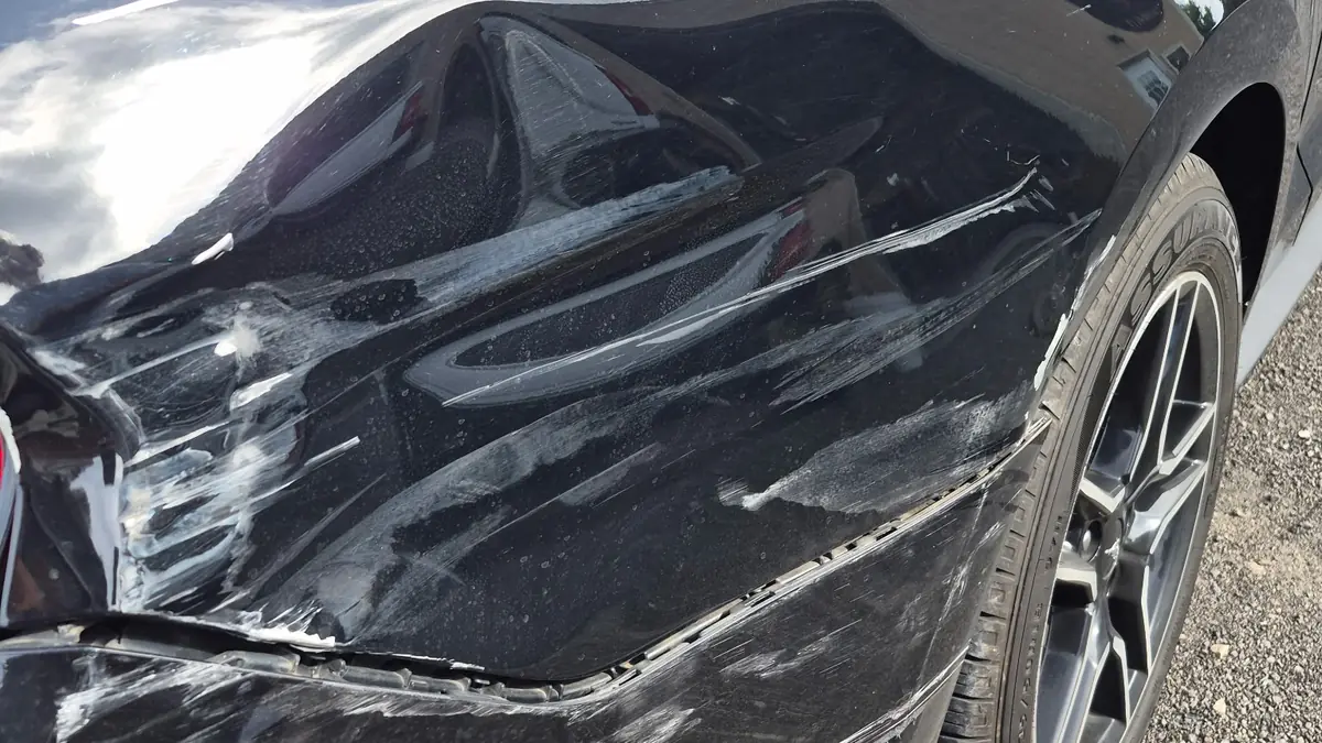 Black Ford Mustang with rear quarter panel and bumper collision damage before repair at Pettie's Auto Body.
