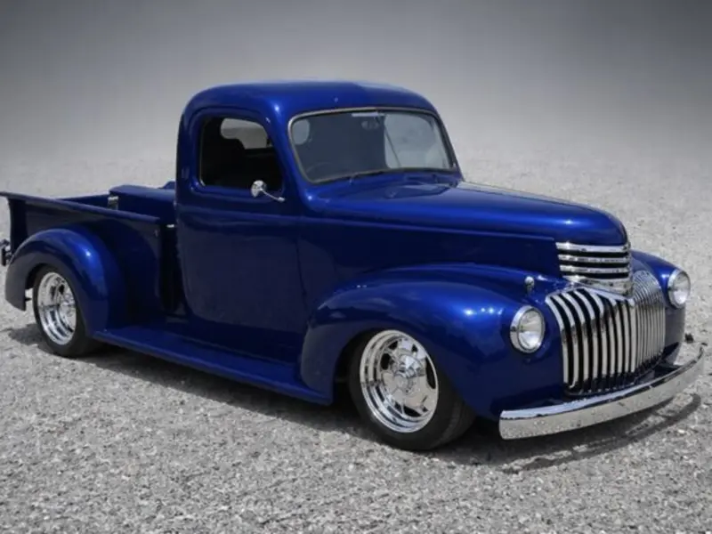 Metallic blue custom classic Chevrolet pickup with finished paint, lowered stance, and polished wheels.